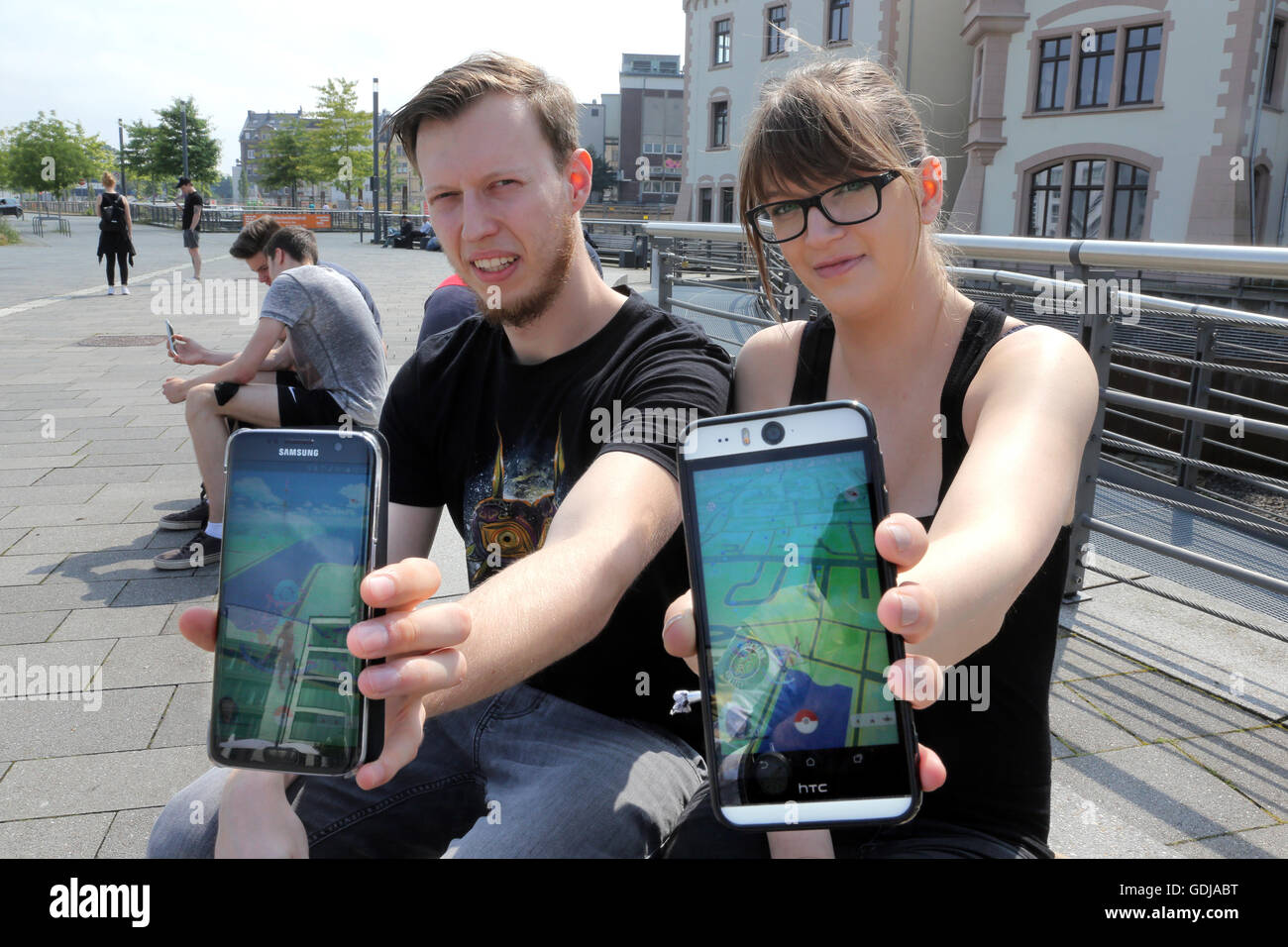 POKEMON GO, young people play the new Nintendo game Pokémon go on their smartphones on Lake Phoenix in Dortmund, Germany. The players try to catch in the real world virtual Pokemon monsters on to their smartphone devices. Stock Photo