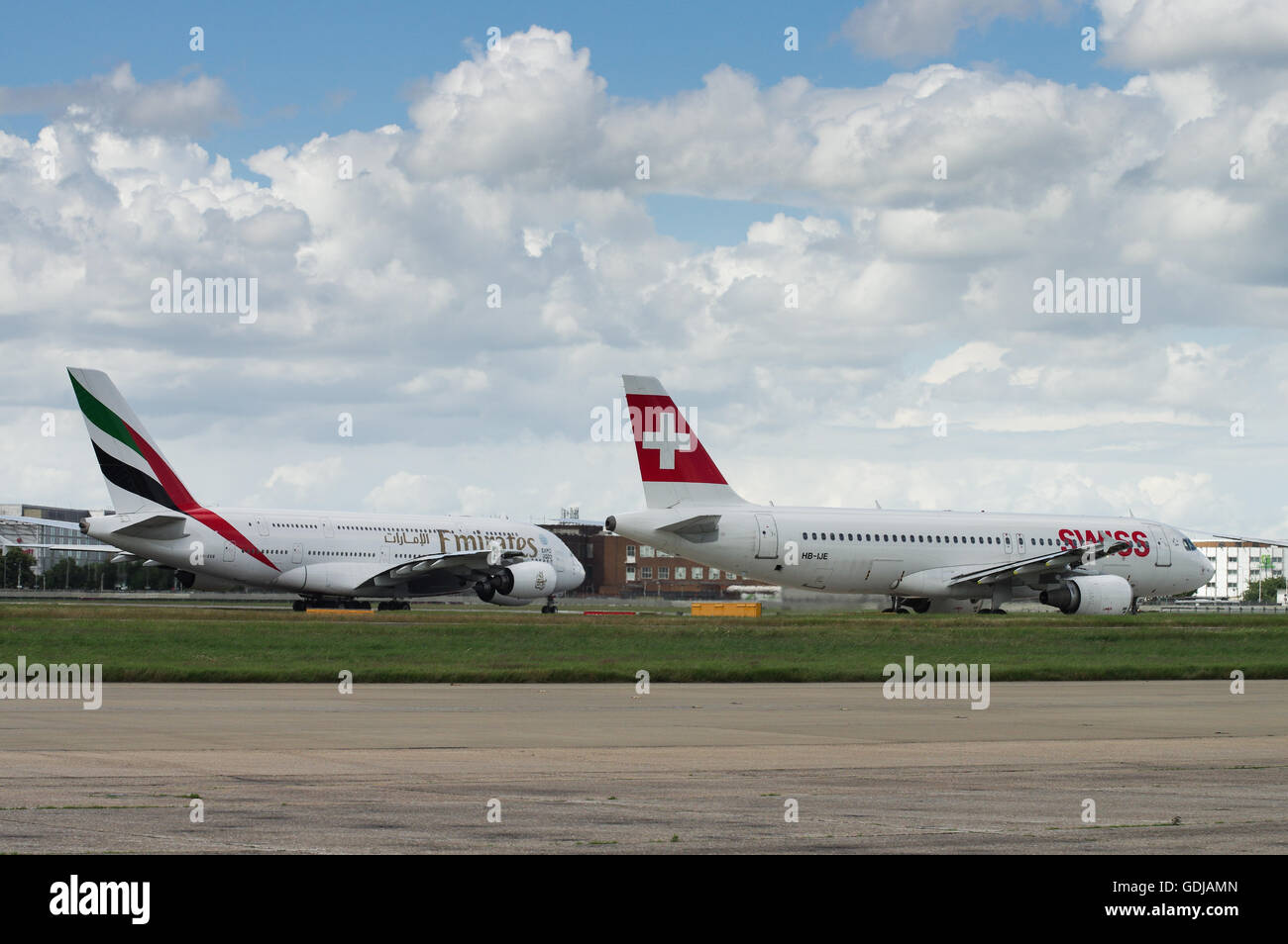 Swiss Airlines and Emirates taxiing next to each other at London Heathrow Airport Stock Photo