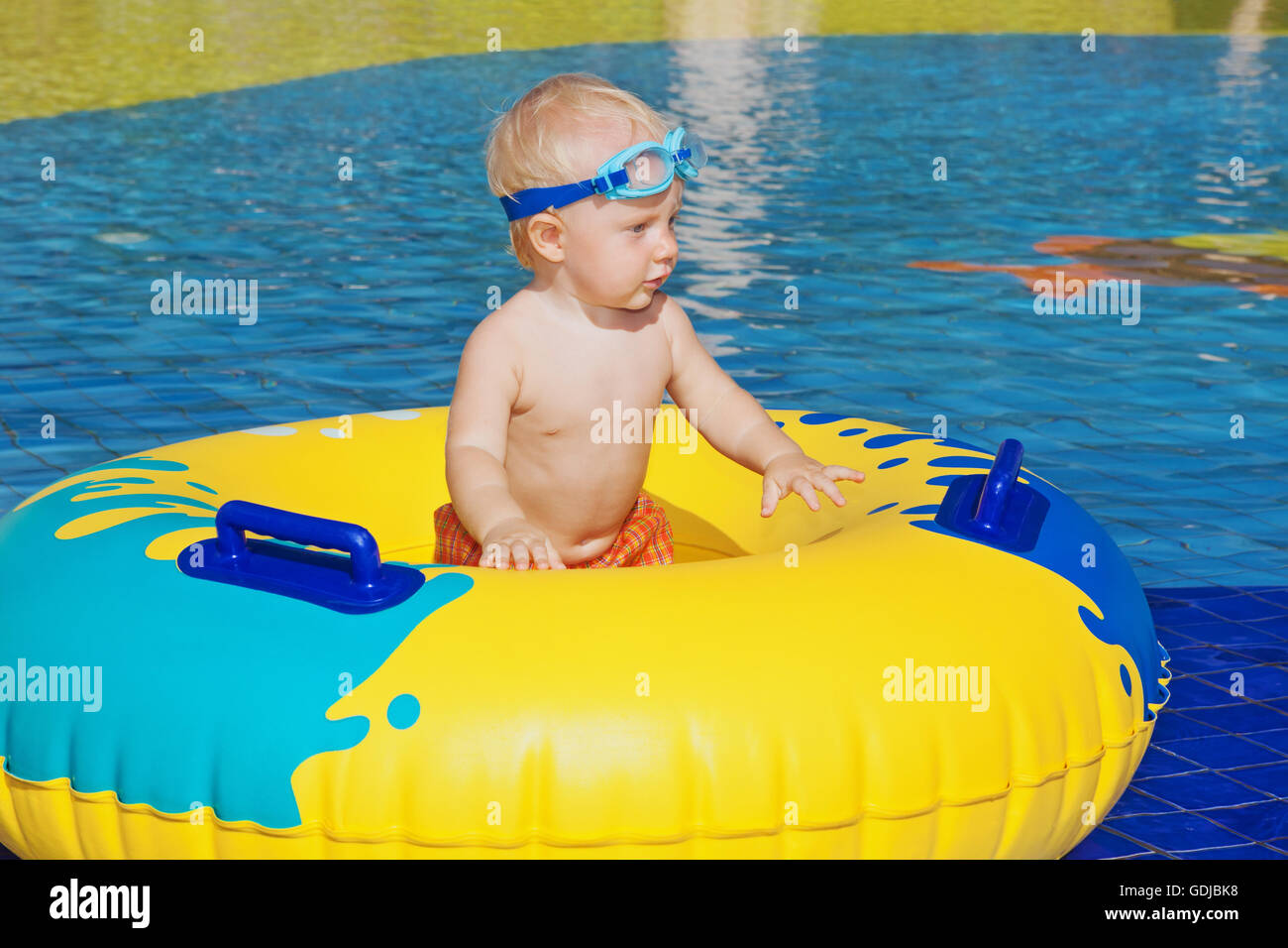 Happy family has a fun in beach pool baby boy sunbathing, swimming