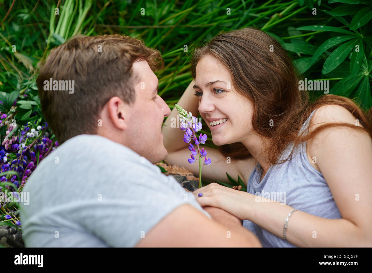 couple in love lying in the grass on a summer meadow Stock Photo