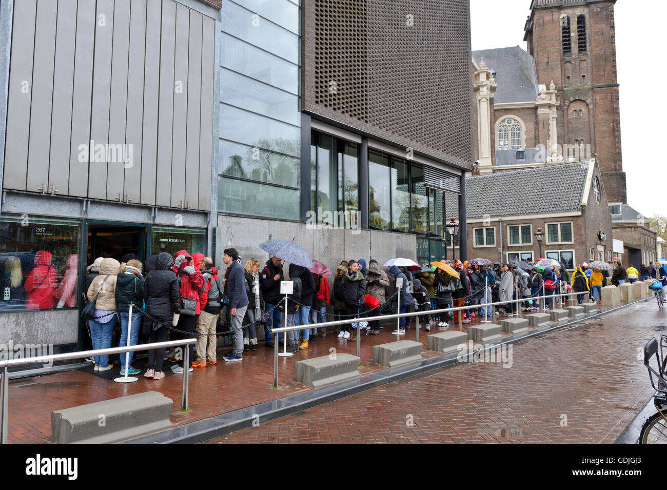 People queuing in the rain outside the Anne Frank Museum in Amsterdam, Holland, Netherlands. Stock Photo
