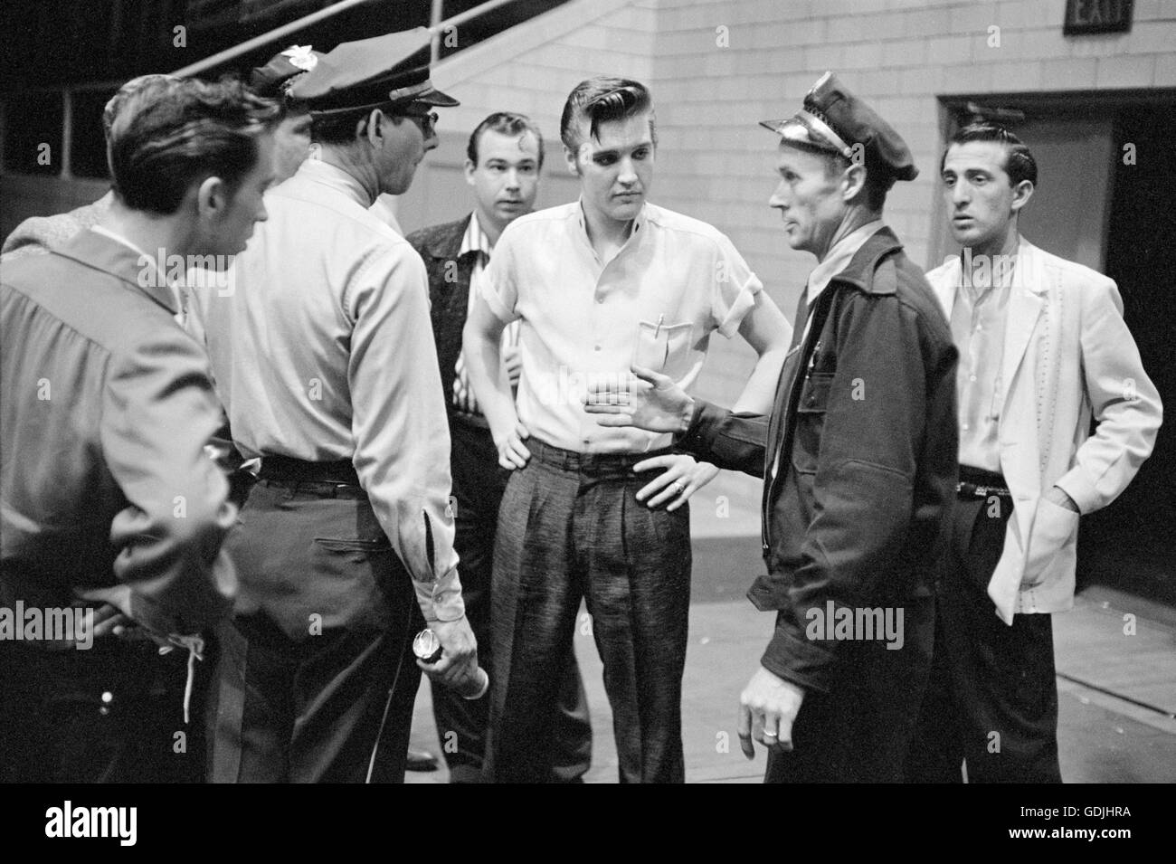 Elvis Presley and bandmates speaking with police officers prior to a performance Stock Photo