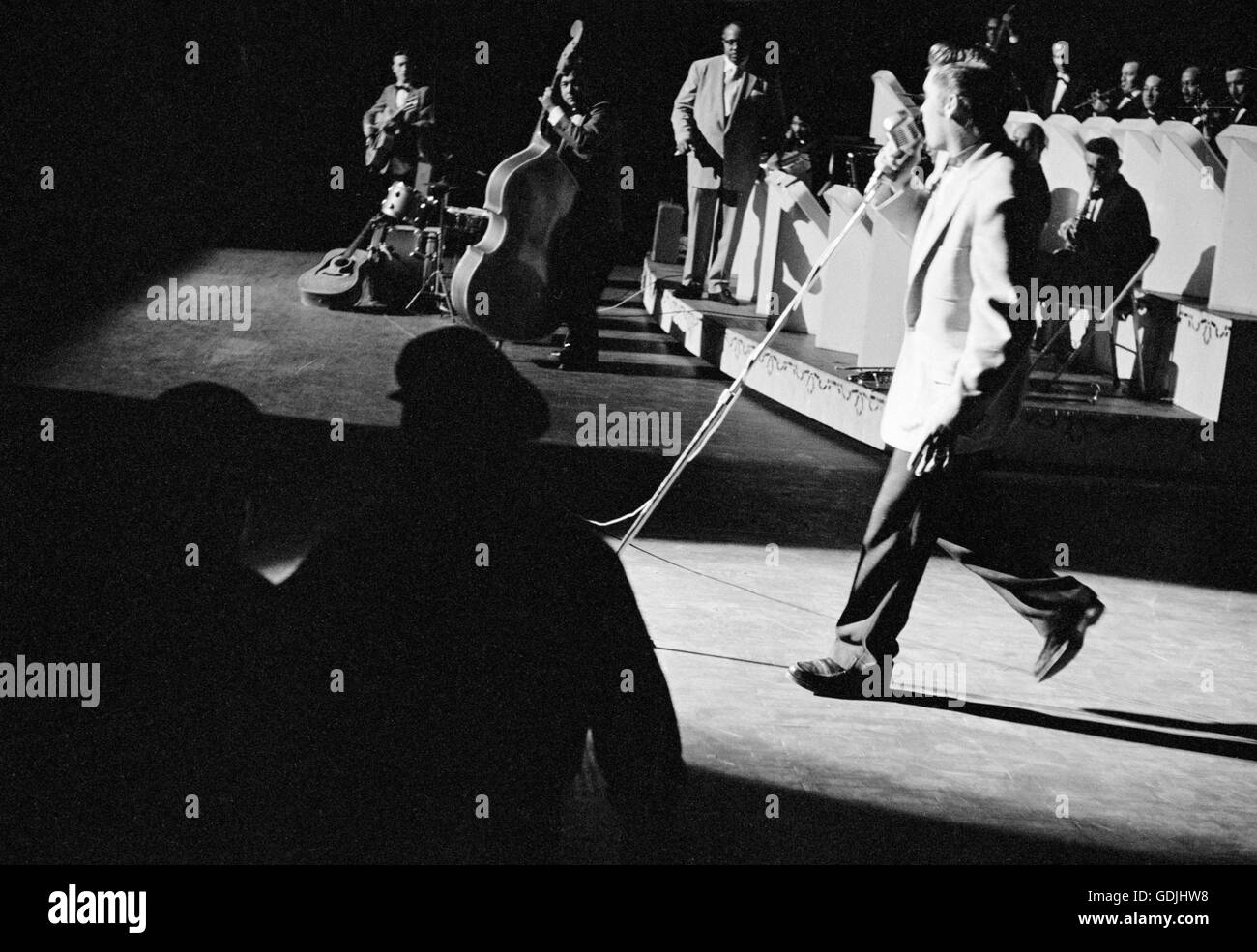 Elvis Presley in concert at the Fox Theater, Detroit, Michigan, May 25, 1956. Also visible on stage are Scotty Moore and Bill Black. Stock Photo