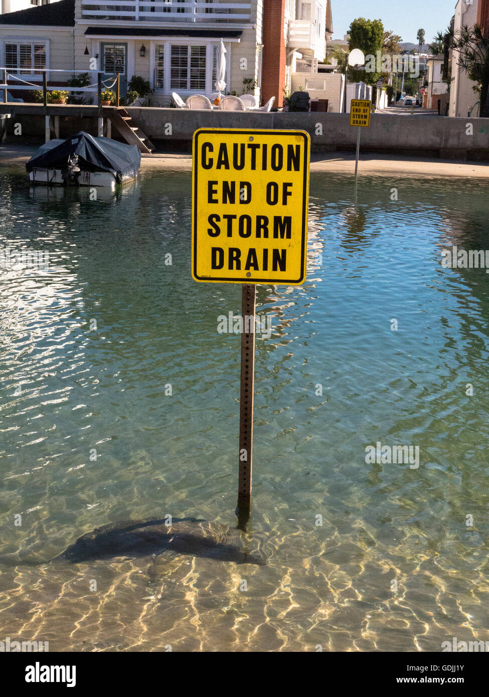 Caution end of storm drain sign in the grand canal Balboa Island  Newport Harbor, California Stock Photo