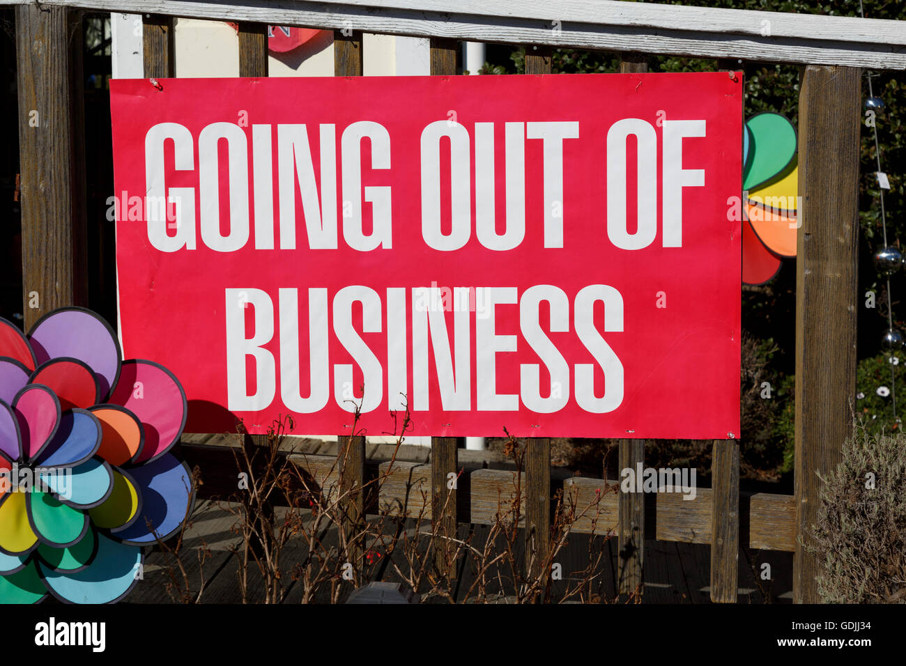 Closeup of a Going out of Business sign nailed to a wooden fence Stock