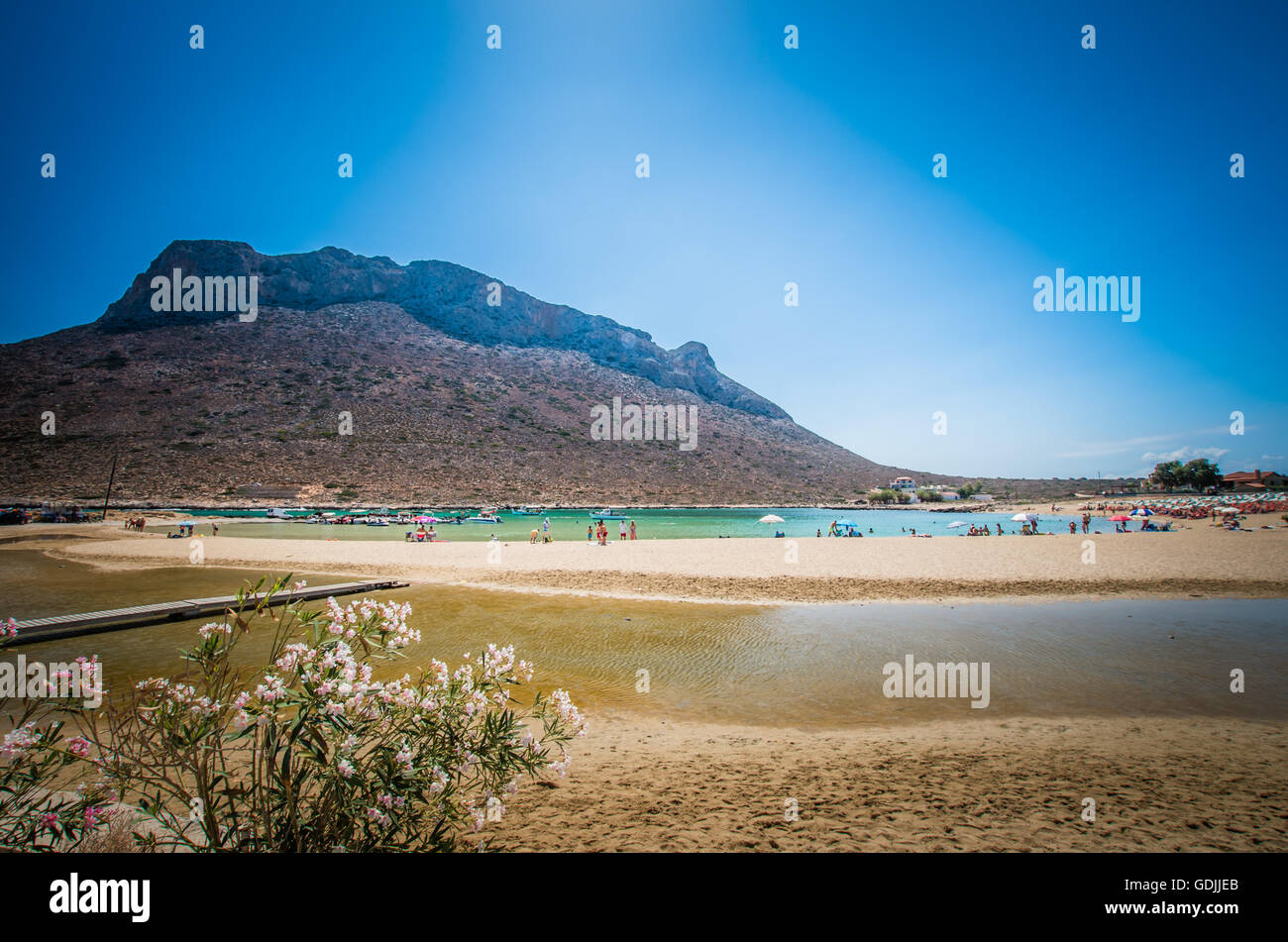 Stavros beach on Crete island, Greece. Tourists relax and bath in crystal clear water. Stock Photo