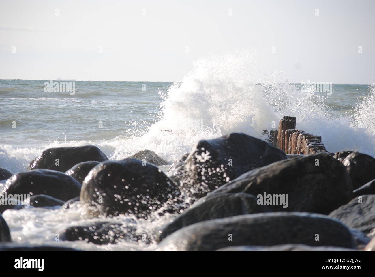 Waves smashes against smooth rocks at sea shore at Stock Photo