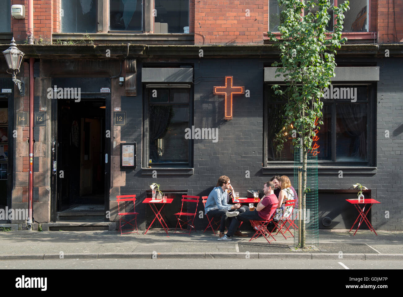 People enjoying a drink outside El Capo bar located on Tariff Street in the Northern Quarter area of Manchester. Stock Photo