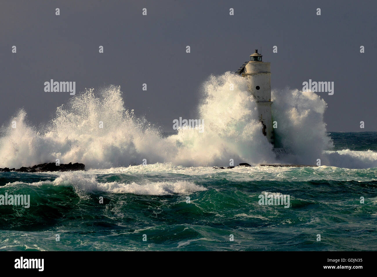 Mangiabarche Sardinia, Italy. Storm. Waves smash against lighthouse or beacon Stock Photo