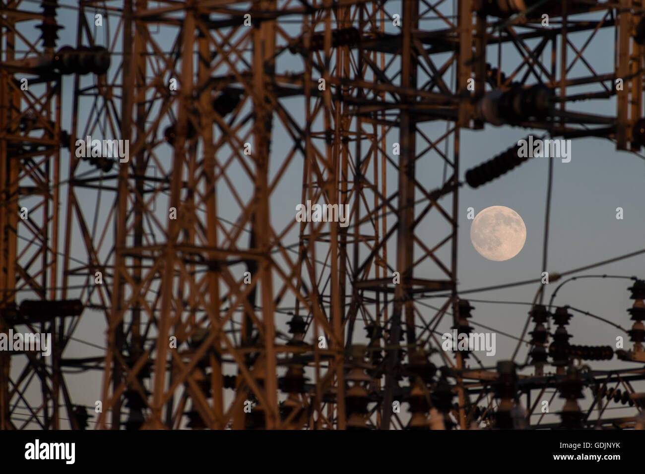 A near full moon rises over Hydro One power station in Kingston, Ont., on July 18, 2016. Stock Photo