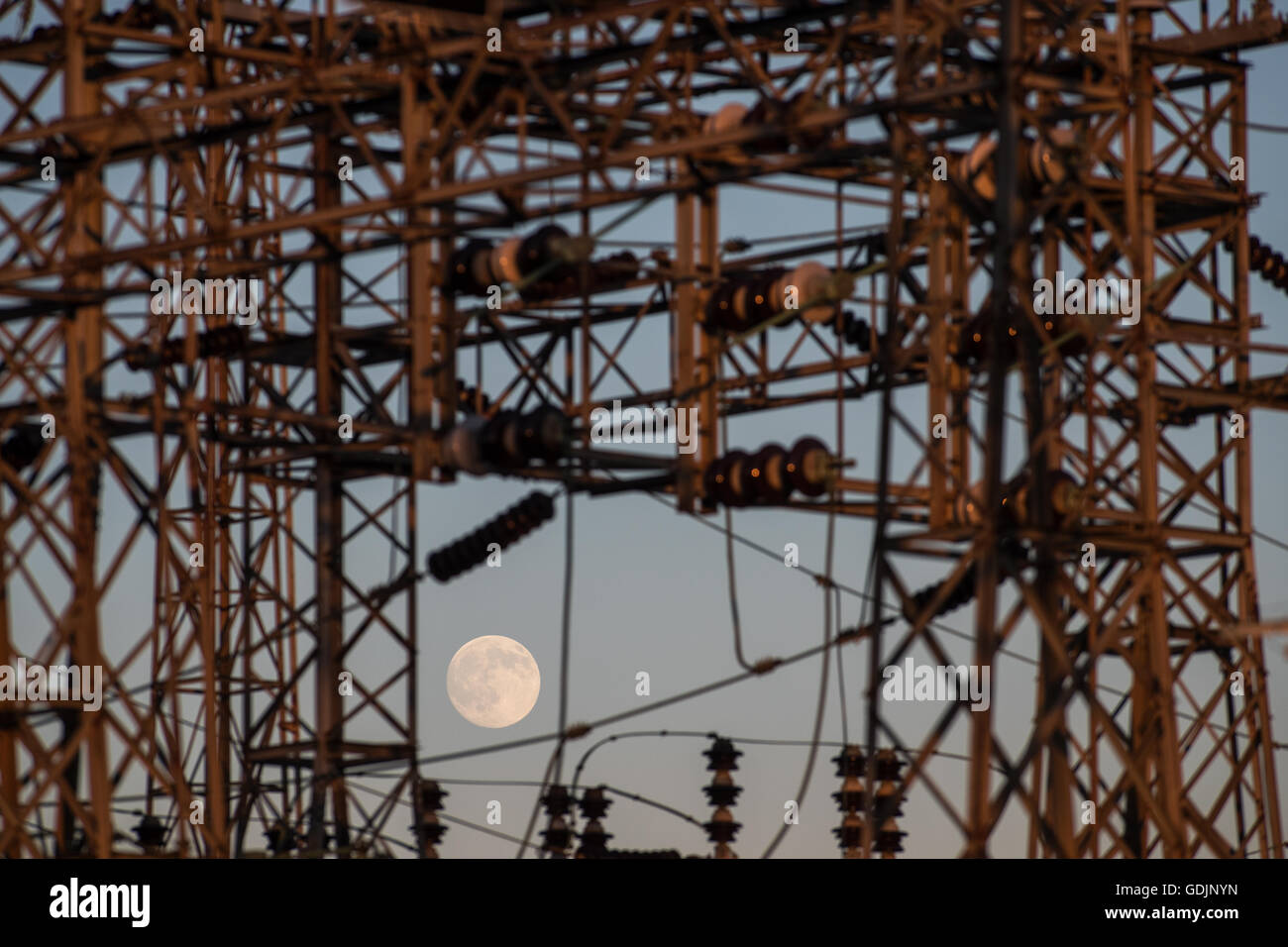 A near full moon rises over Hydro One power station in Kingston, Ont., on July 18, 2016. Stock Photo