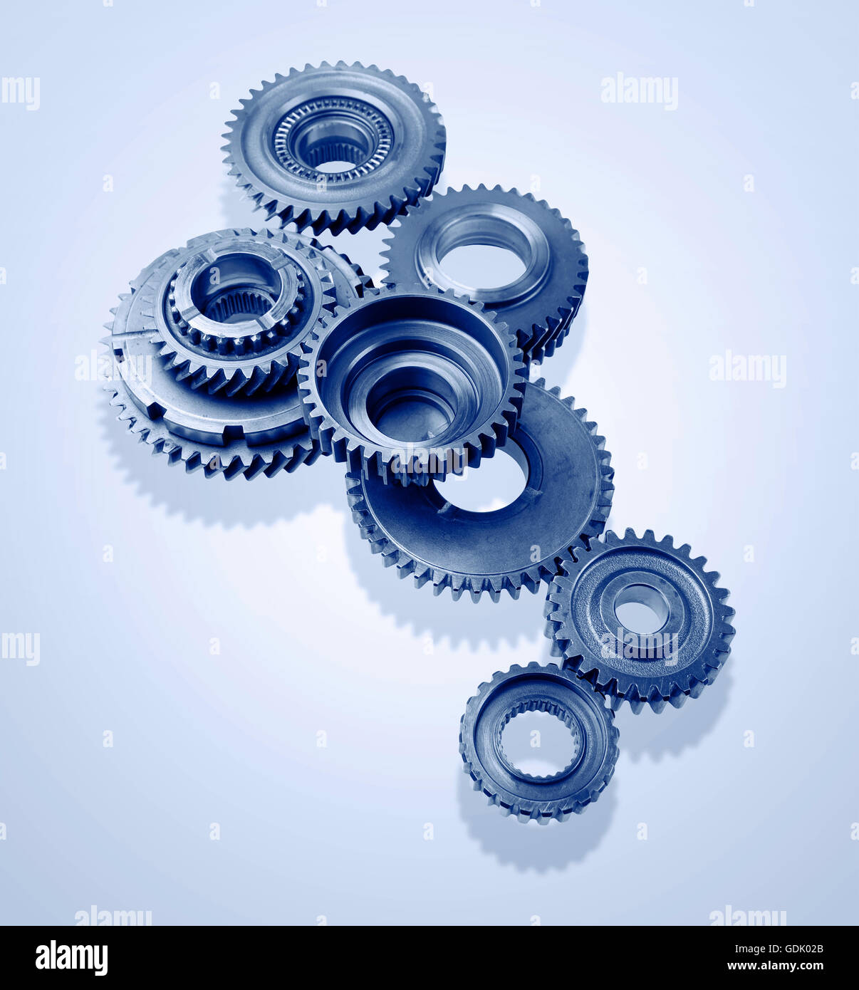 Metal gears on blue background Stock Photo - Alamy