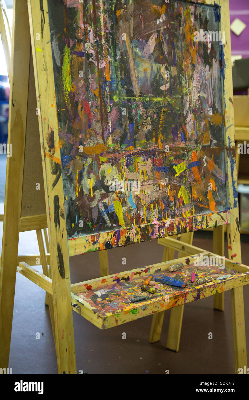 A paint splattered easel in a UK primary school classroom Stock Photo