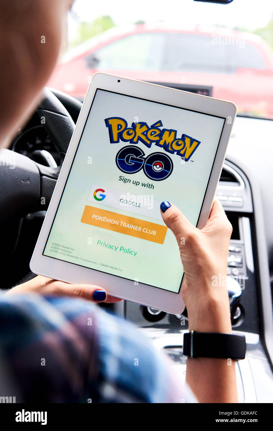 Woman sitting in a car and playing a Pokemon Go game Stock Photo - Alamy