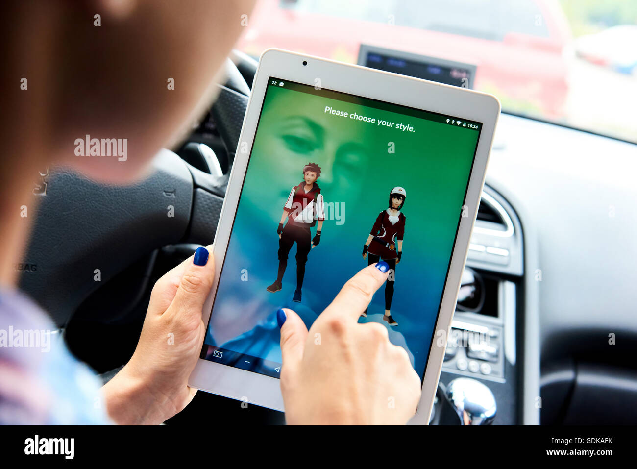 Woman sitting in a car and playing a Pokemon Go game Stock Photo - Alamy