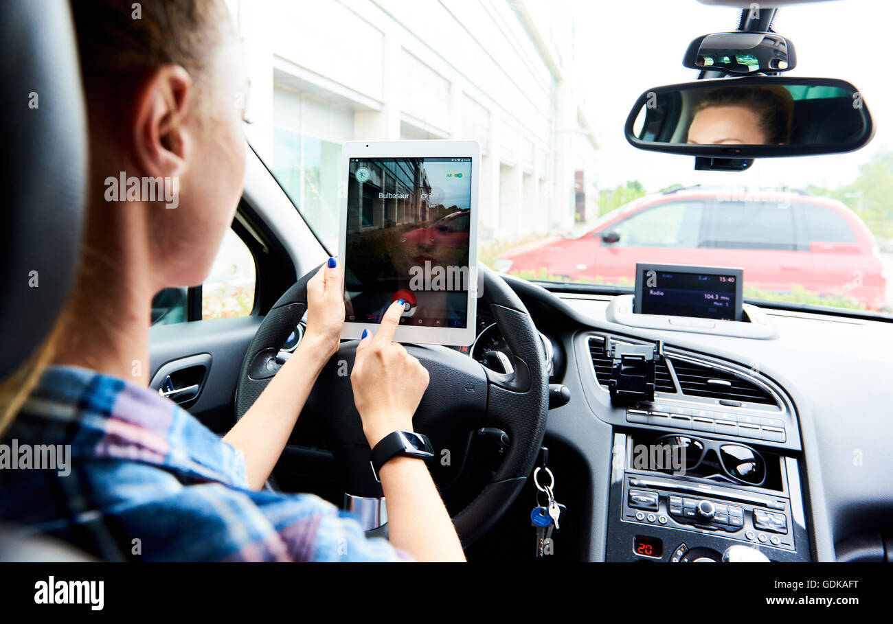 Woman sitting in a car and playing a Pokemon Go game Stock Photo - Alamy