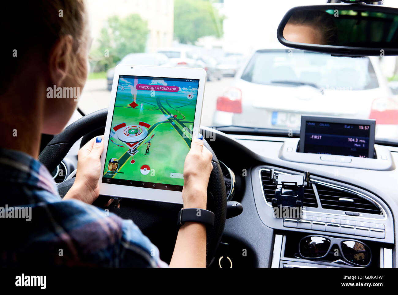 Woman sitting in a car and playing a Pokemon Go game Stock Photo - Alamy