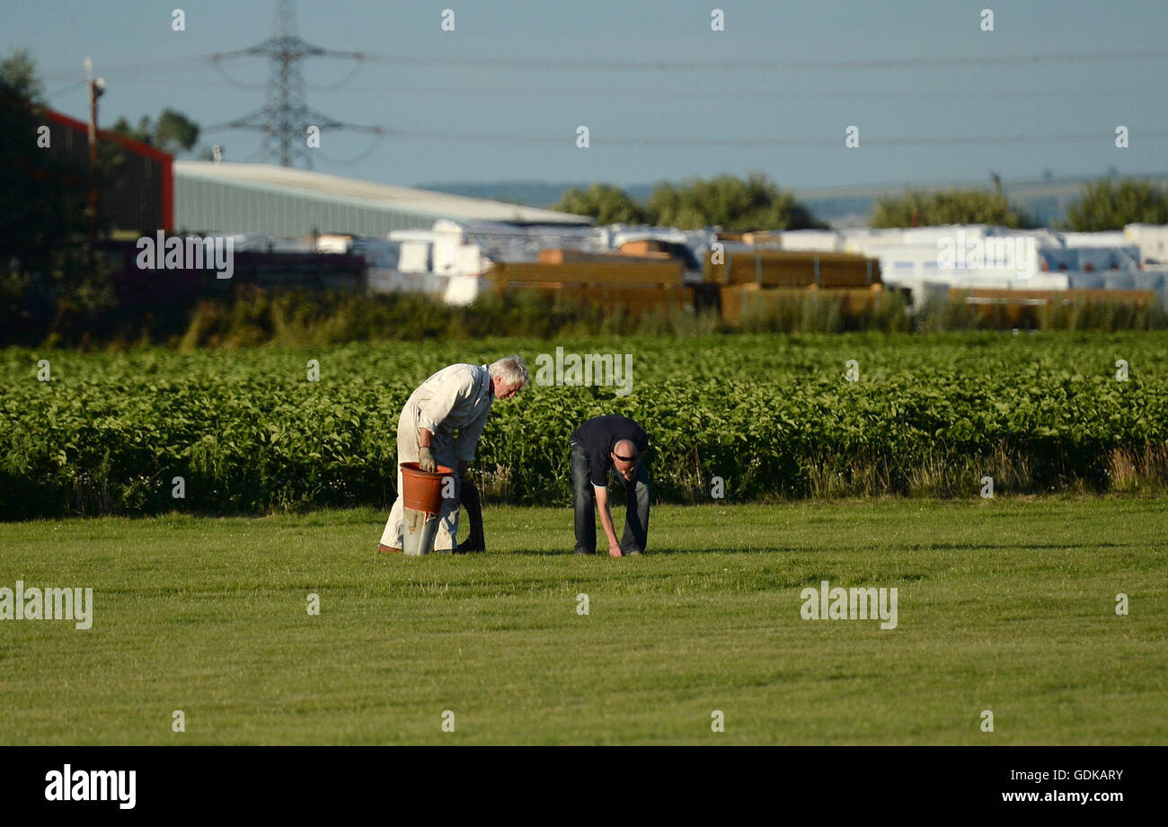 People survey the scene at Breighton airport near Selby, north Yorkshire, where five people have been seriously hurt in a helicopter crash at the aerodrome. Stock Photo