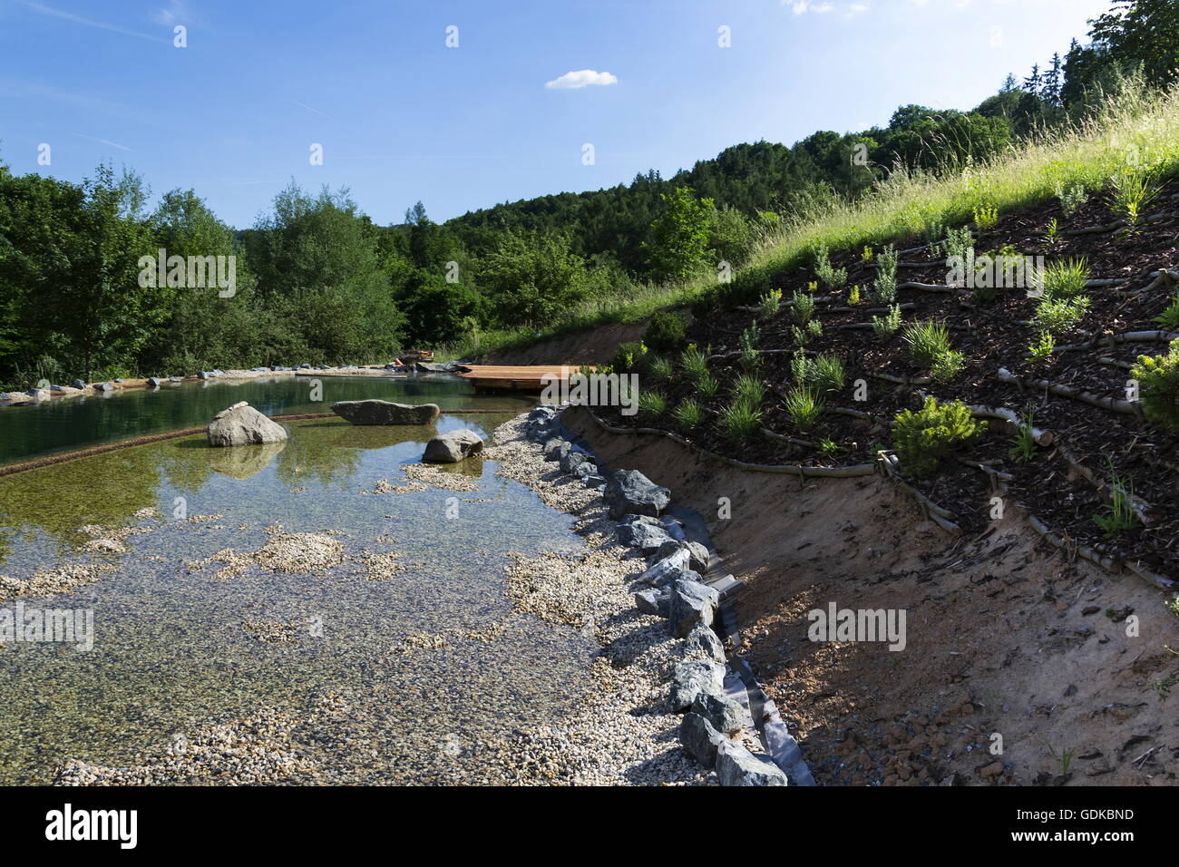 Natural swimming pond purifying water without chemicals through filters and plants Stock Photo