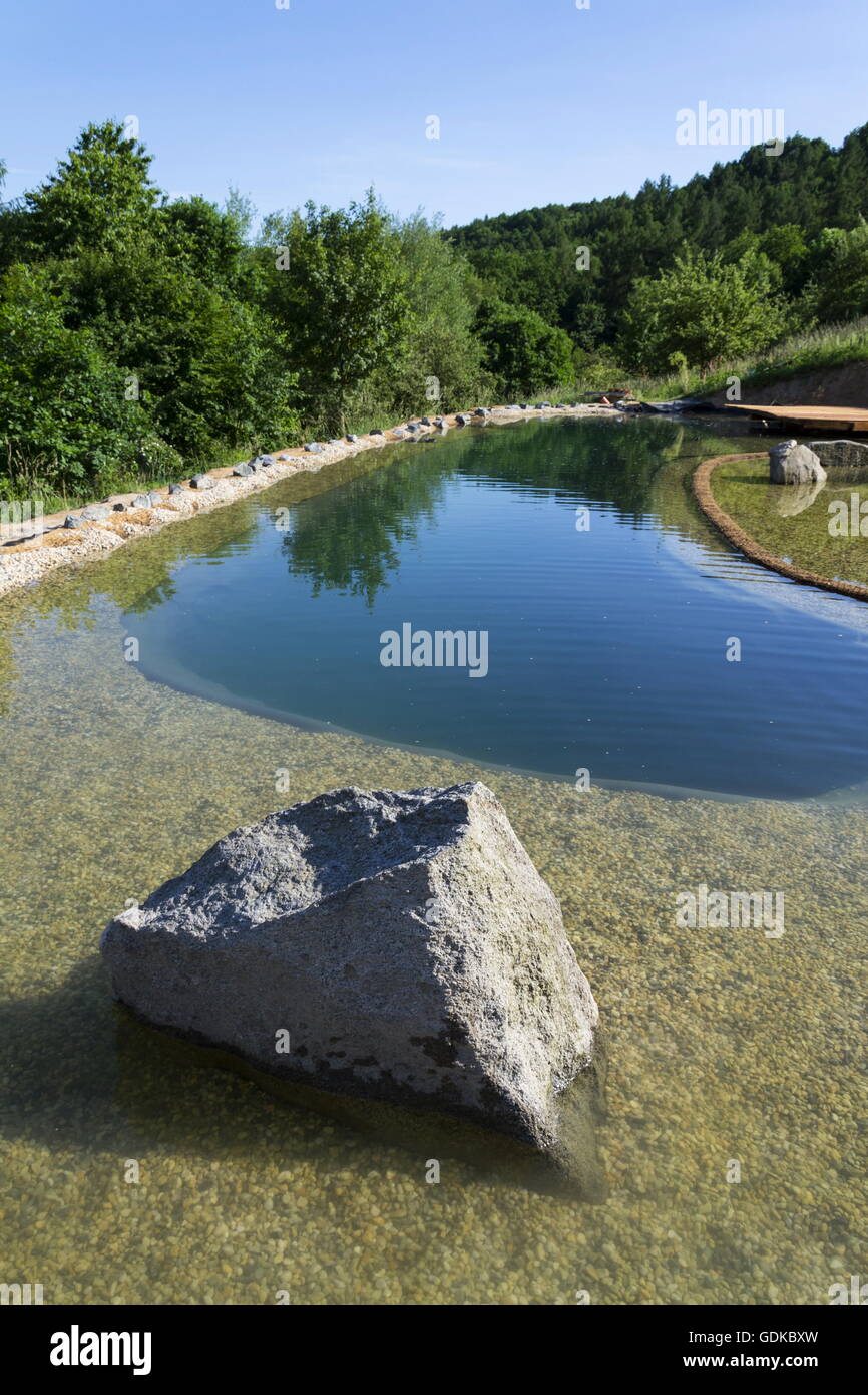 Natural swimming pond purifying water without chemicals through filters and plants Stock Photo