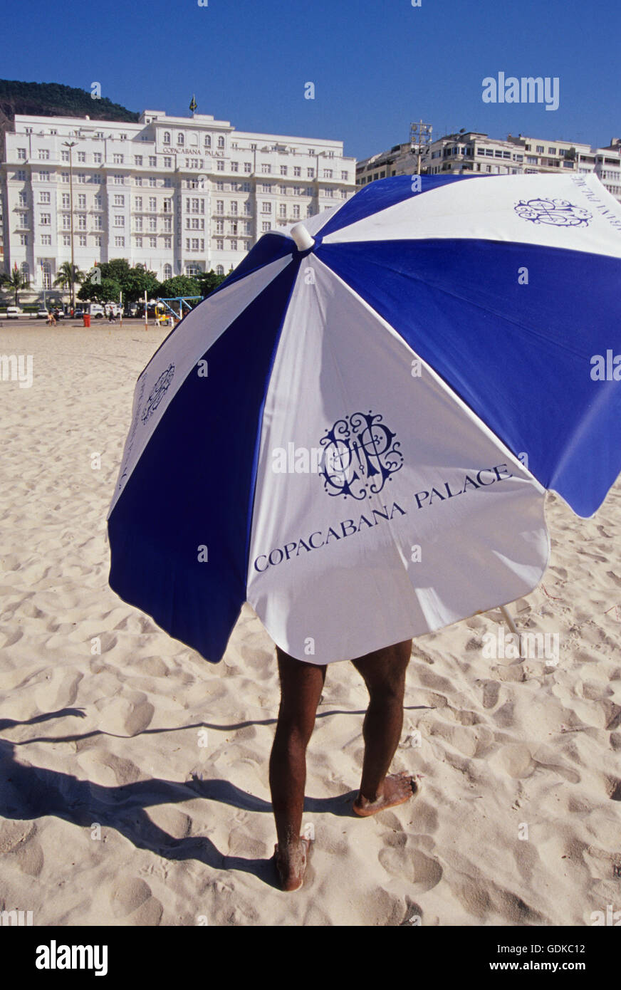 Service to guest - umbrellas at the beach - The Belmond Copacabana Palace is a luxury hotel located on Copacabana Beach in Rio de Janeiro, Brazil - the famous hotel is widely considered as South America's premier hotel, and has received the rich and famous for over 90 years. It faces the coast, and consists of an 8-story main building and a 14-story annex. The Art Deco hotel was designed by French architect Joseph Gire. Stock Photo