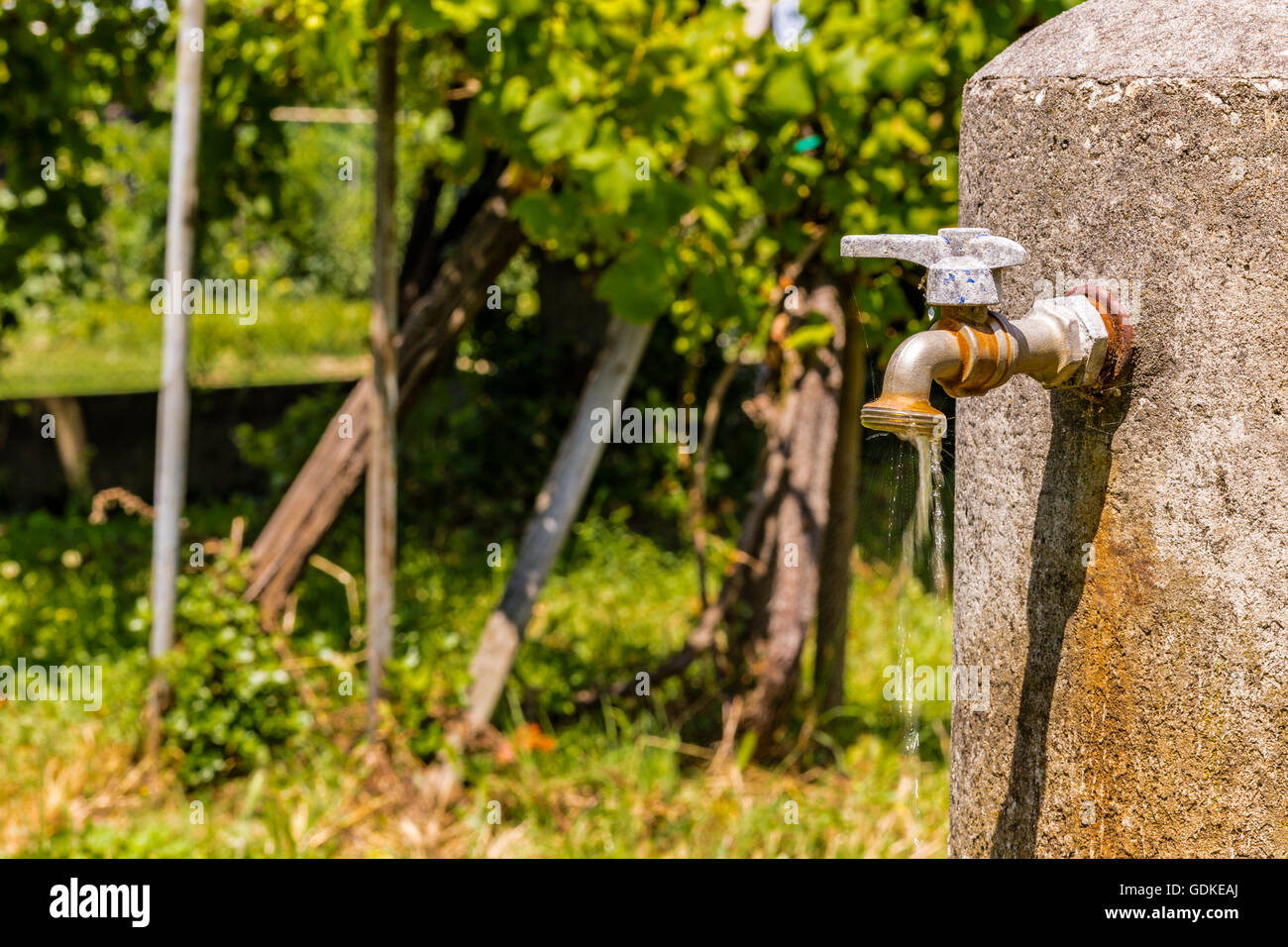 old rusty faucet leaks, a flow of water is coming down Stock Photo Alamy