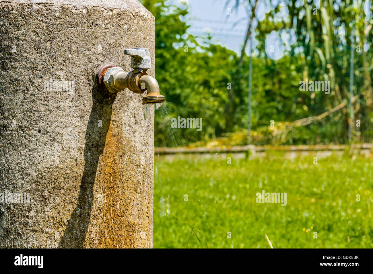old rusty faucet leaks, a flow of water is coming down Stock Photo Alamy