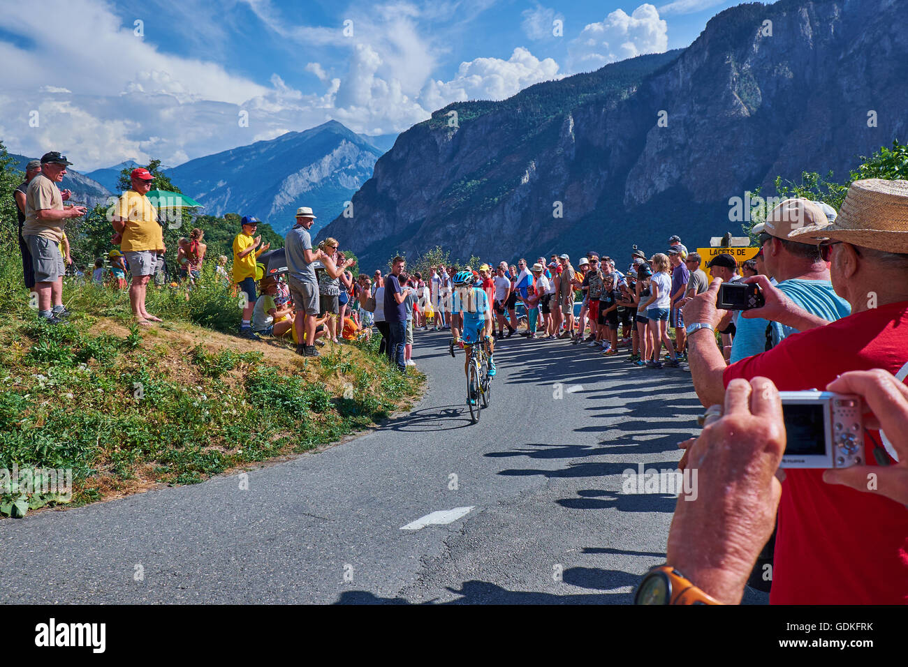 Astana rider with a look to his heart rate monitor under the open suit, on his way up the mountain roads at Montvernier, in tdf Stock Photo