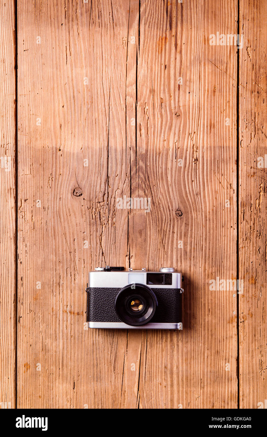 Vintage camera laid on table. Wooden background. Studio shot Stock Photo