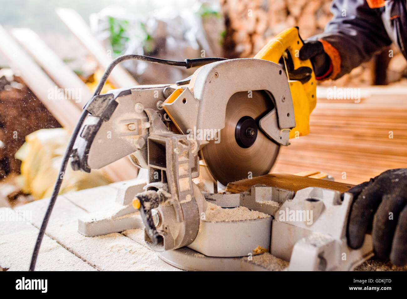 Carpenter working. Man cutting plank by circular saw Stock Photo - Alamy