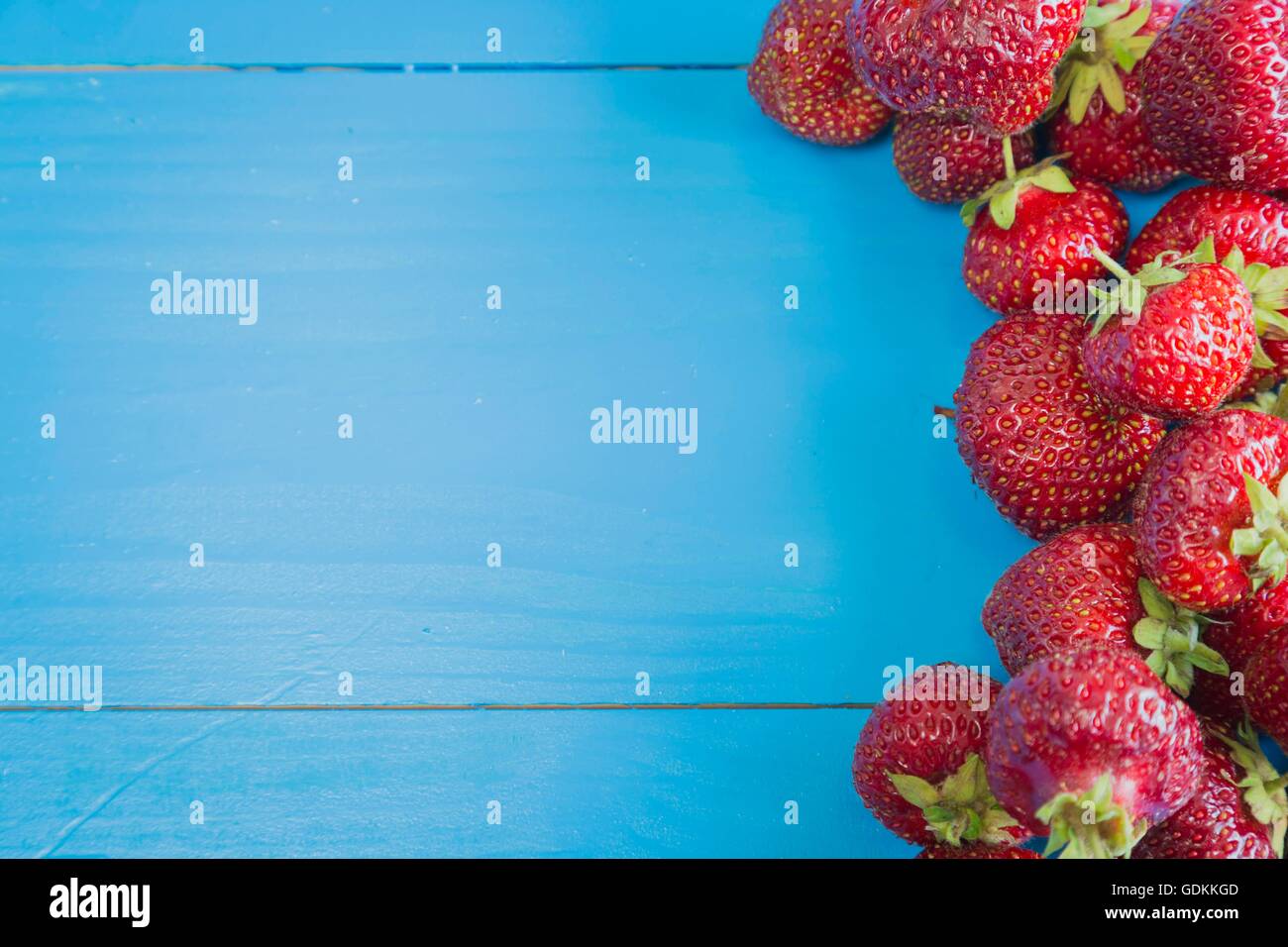Fresh strawberries on blue background Stock Photo - Alamy