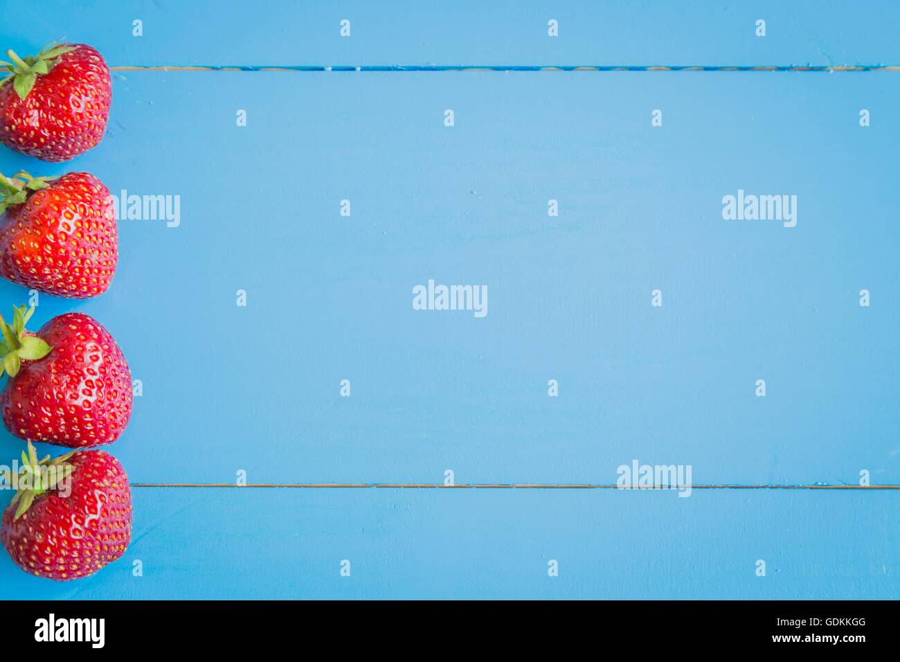 Fresh strawberries on blue background Stock Photo - Alamy