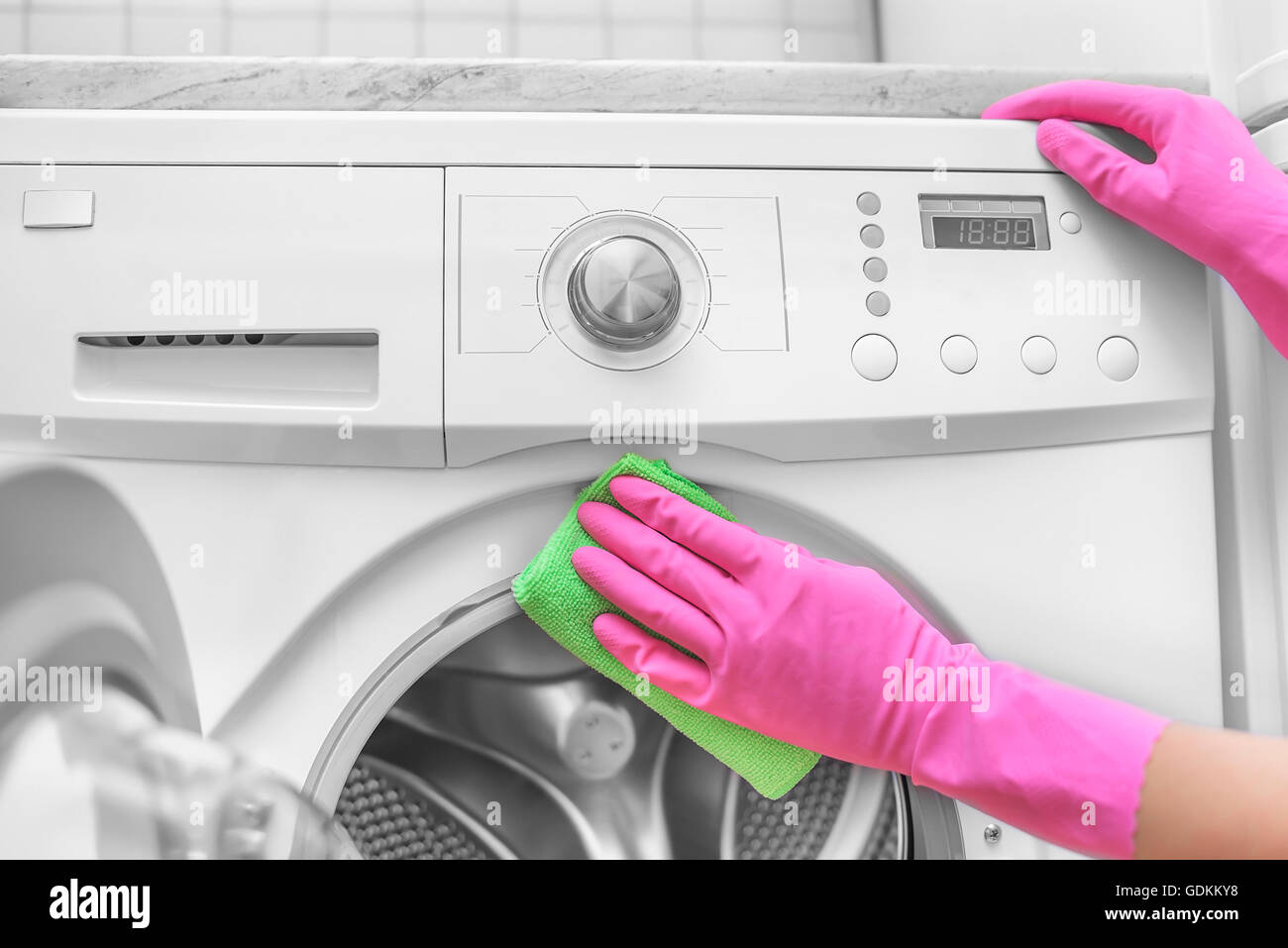 Female hands in gloves washing washing machine. Close-up. Stock Photo