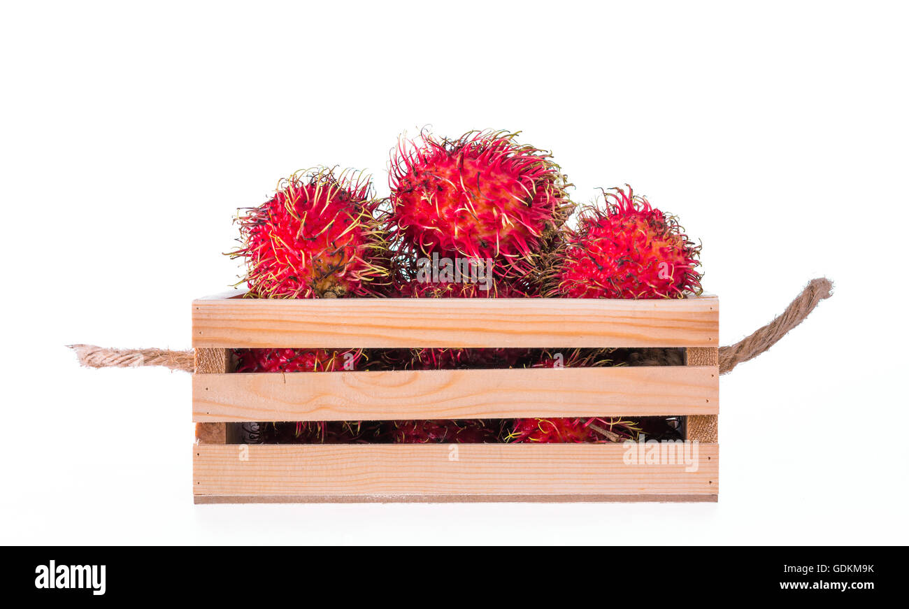 Fresh rambutan in wooden crate on white background Stock Photo - Alamy