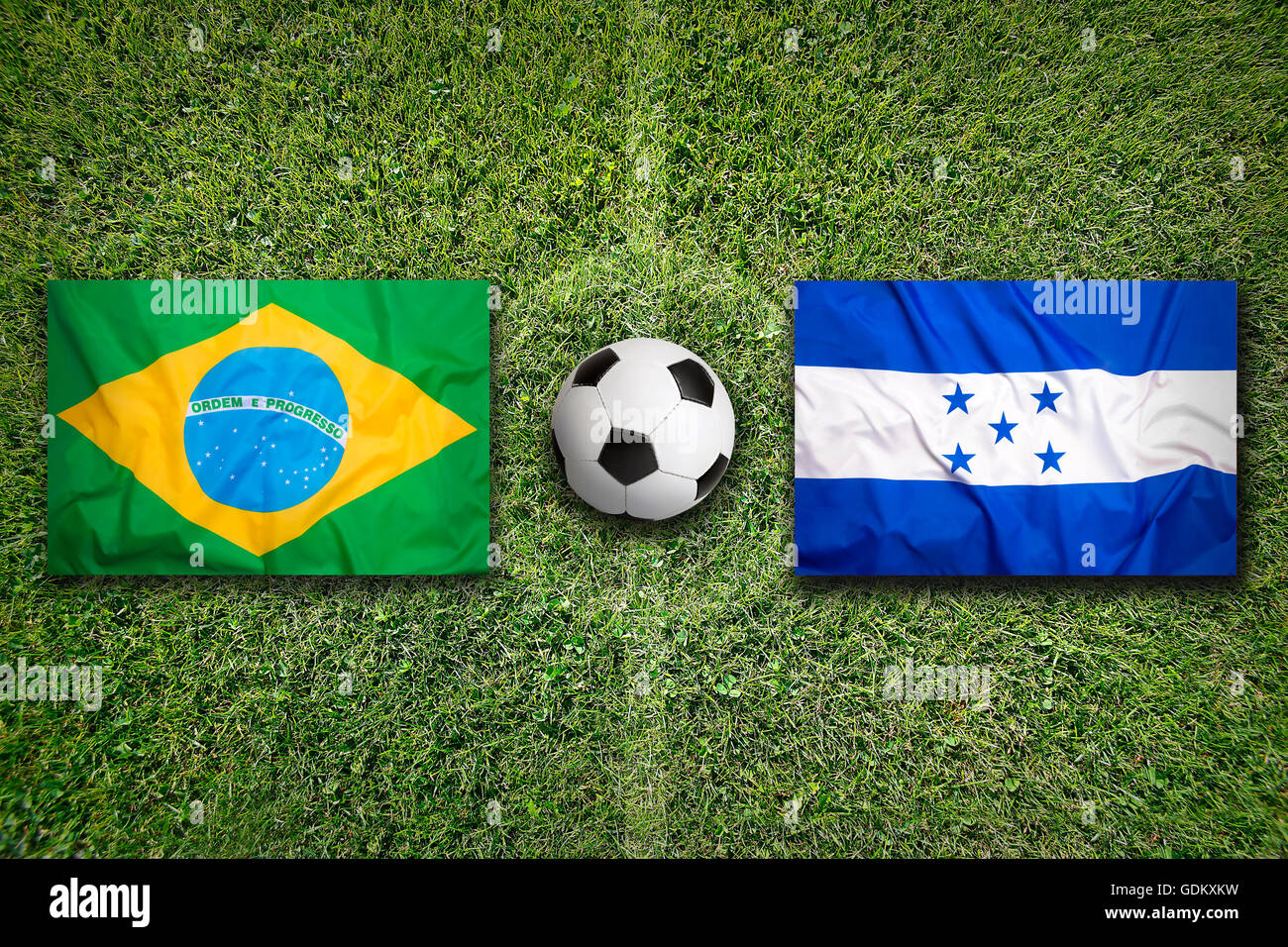 Brazil vs. Honduras flags on green soccer field Stock Photo