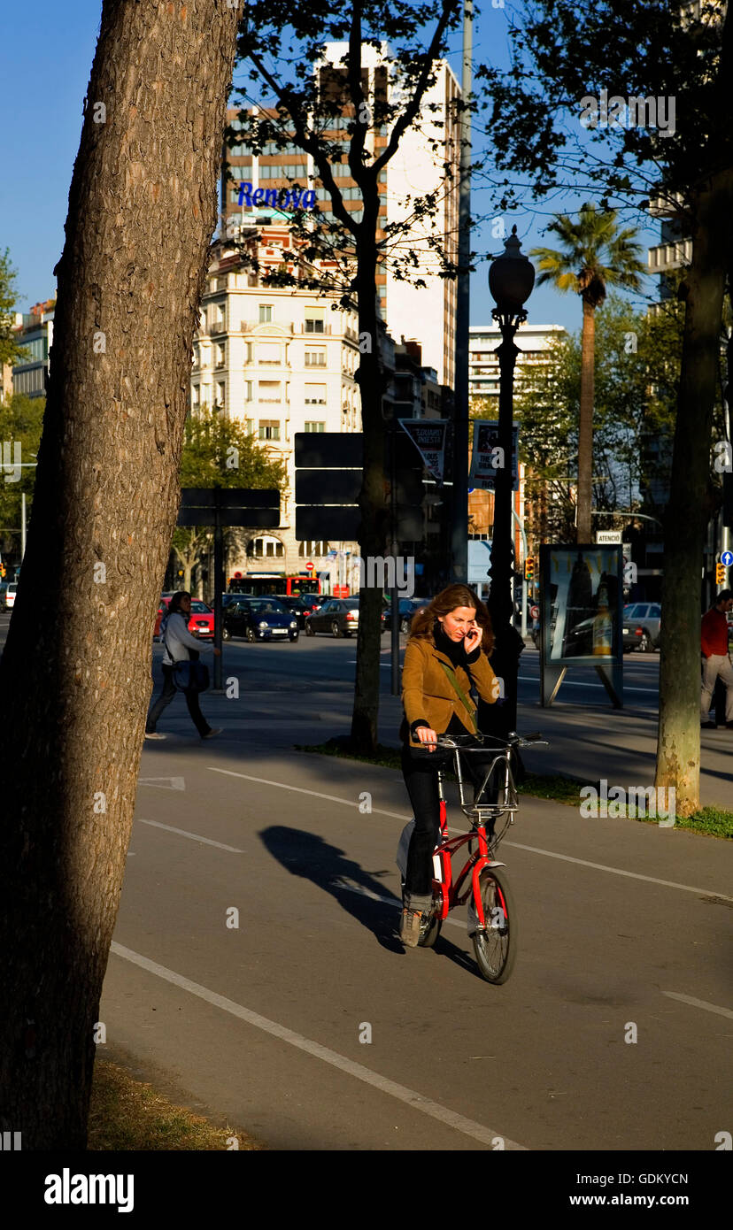 Woman riding bike in Diagonal Avenue, Barcelona, Spain Stock Photo