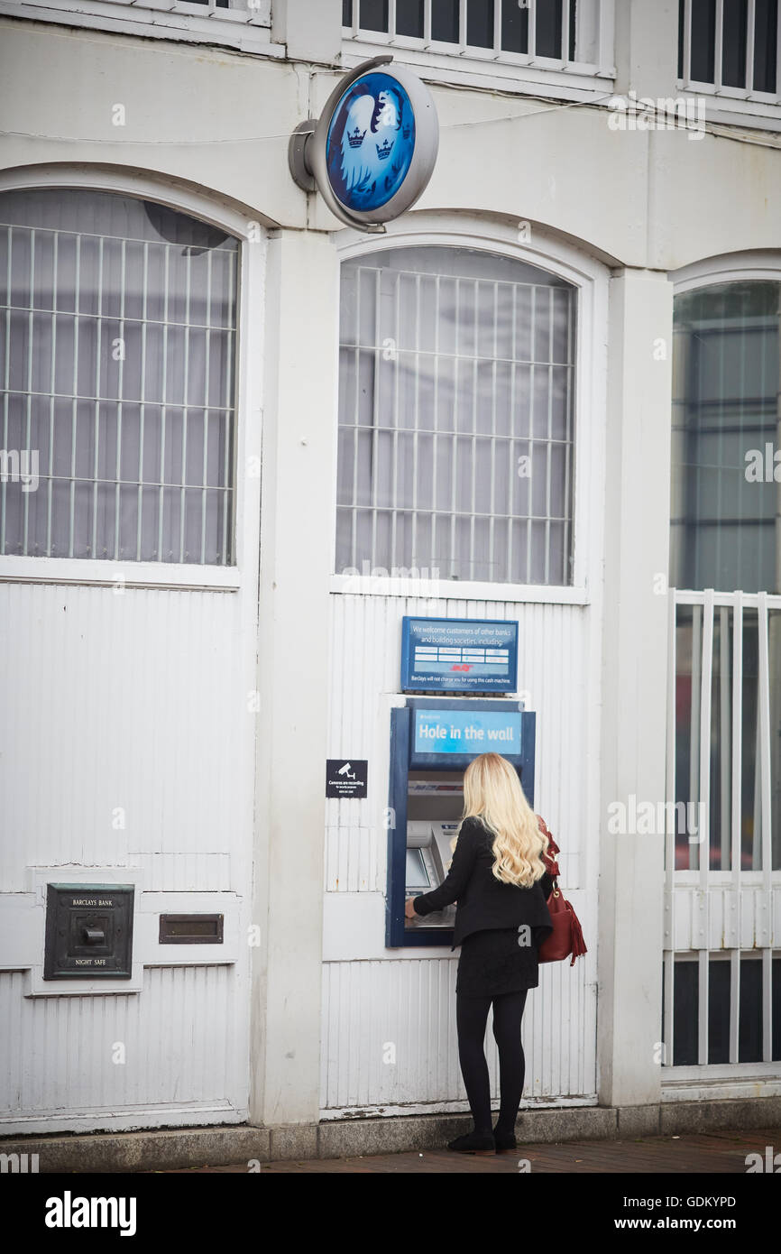 Wilmslow Barclays bank cash machine atm  Young lady girl woman she using cash machine in street town centre single night safe de Stock Photo