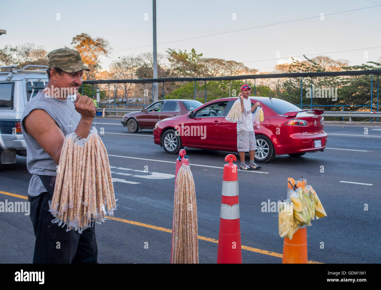 Hawkers selling cashews and dried fruit at a toll booth stop along Highway 27 (Autopista José Maria Castro Madriz). Stock Photo