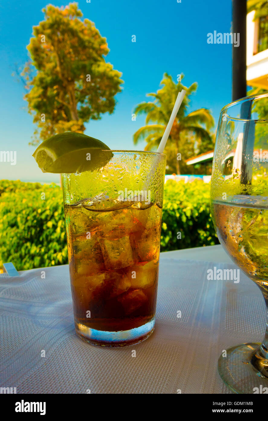 A Cuba Libre (Rum and coke) sitting on a table overlooking a resort