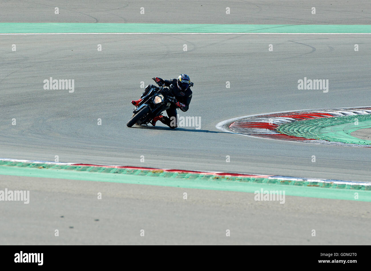A racing motorcycle leans into the turn at the Dubai Autodrome Stock