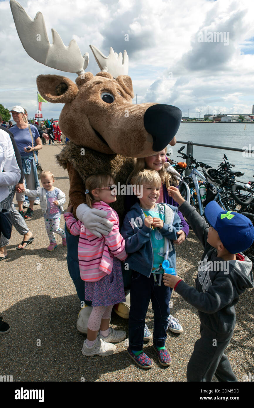 Copenhagen, Denmark – July 18, 2016:  Kids have fun with a Santa reindeer during the Santa Claus’s visit to the Little Mermaid sculpture at the harbor promenade, Langelinie in Copenhagen. The Santa’s participates in the World Santa Claus Congress 2016. The congress has taken place since 1957. The venue and organizer is Bakken, the world’s oldest amusement park and located north of Copenhagen. Credit:  OJPHOTOS/Alamy Live News Stock Photo