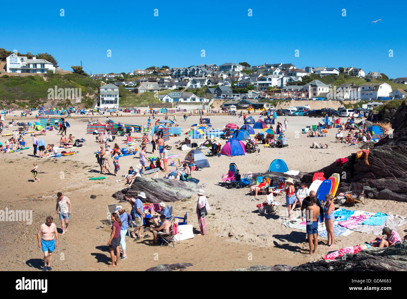Polzeath, Cornwall, U.K. 18th July 2016. Surfers and families flock to the beach on a hot and sunny day in Cornwall. Situated on North Cornwall's Atlantic coast,  Polzeath is a popular location for surfers.  Credit:  Mark Richardson/17�Թ����� Live News Stock Photo