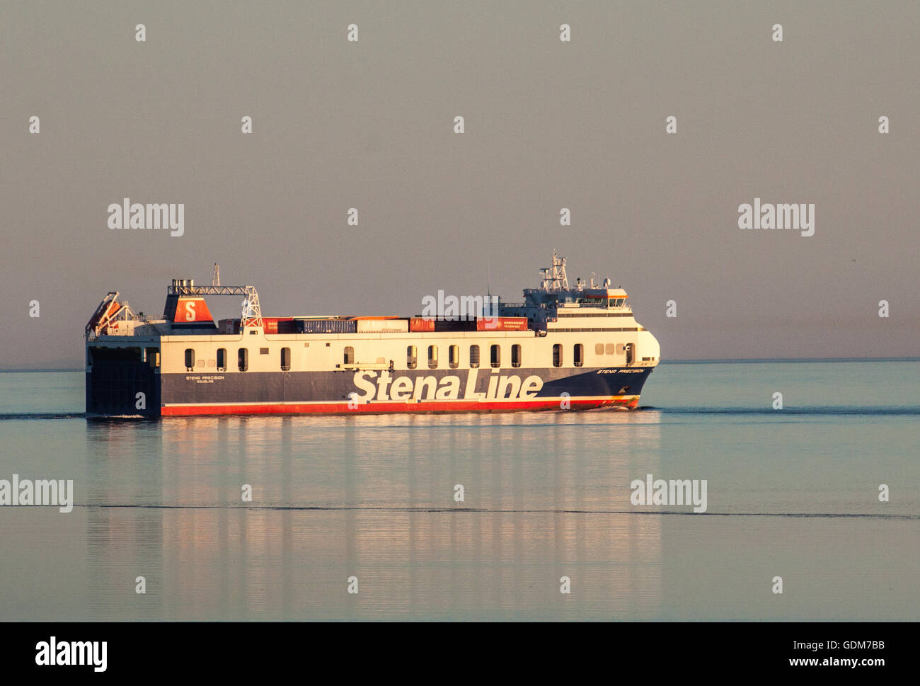 Heysham Lancashire, United Kingdom, 18th July 2016,  Caught in the Evening sunshine the MV Stenna Precision leaves Hesham Harbour bound for Douglas on the Isle of Man, Heading out through a flat Morecambe Bay to the Irish and the Isle of Mann beyond. Credit:  David Billinge/Alamy Live News Stock Photo