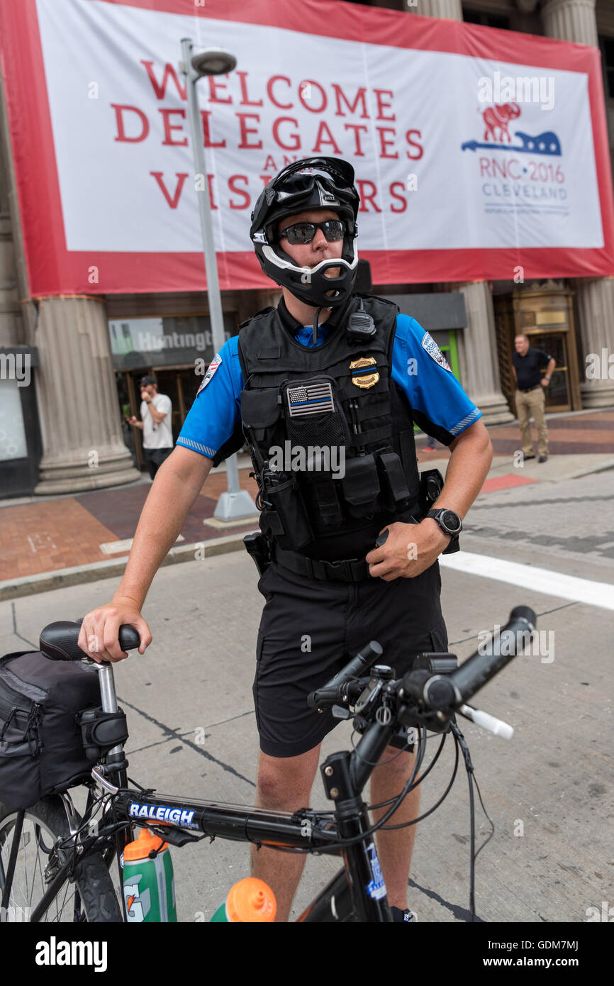 Cleveland, Ohio, USA. 18th July, 2016. A bicycle policeman in riot gear watches a protest march through downtown outside the Republican National Convention at the Quicken Loans Center July 18, 2016 in Cleveland, Ohio. Credit:  Planetpix/Alamy Live News Stock Photo