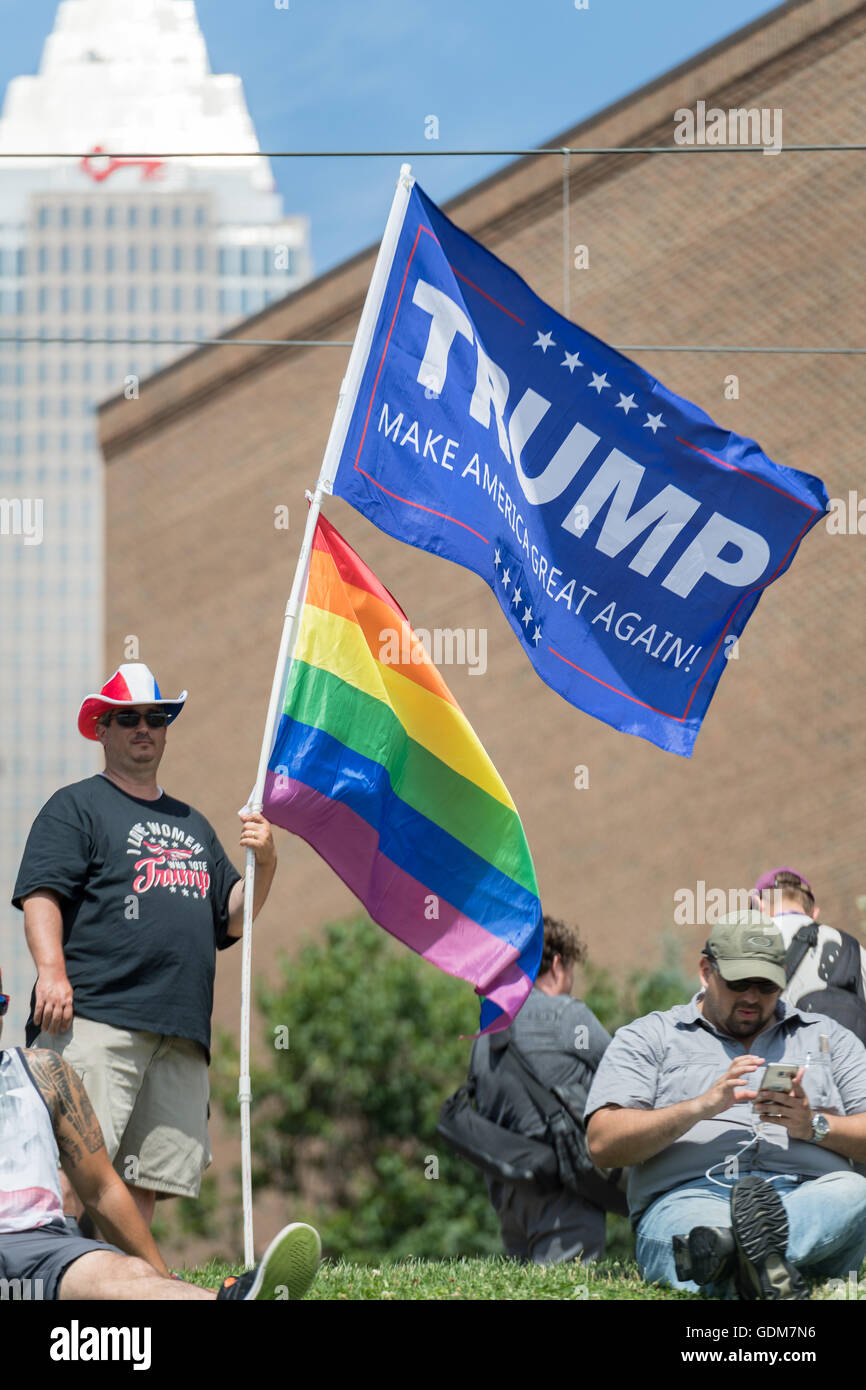 Cleveland, Ohio, USA. 18th July, 2016. A gay Donald Trump supporter holds a rainbow flag during a rally near the Republican National Convention at the Quicken Loans Center July 18, 2016 in Cleveland, Ohio. Credit:  Planetpix/Alamy Live News Stock Photo