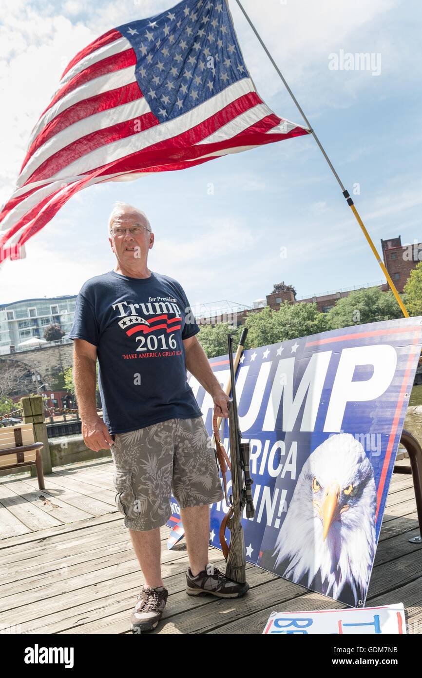 Cleveland, Ohio, USA. 18th July, 2016. A Trump supporter stands holding a hunting rifle during a rally near the Republican National Convention at the Quicken Loans Center July 18, 2016 in Cleveland, Ohio. Credit:  Planetpix/Alamy Live News Stock Photo