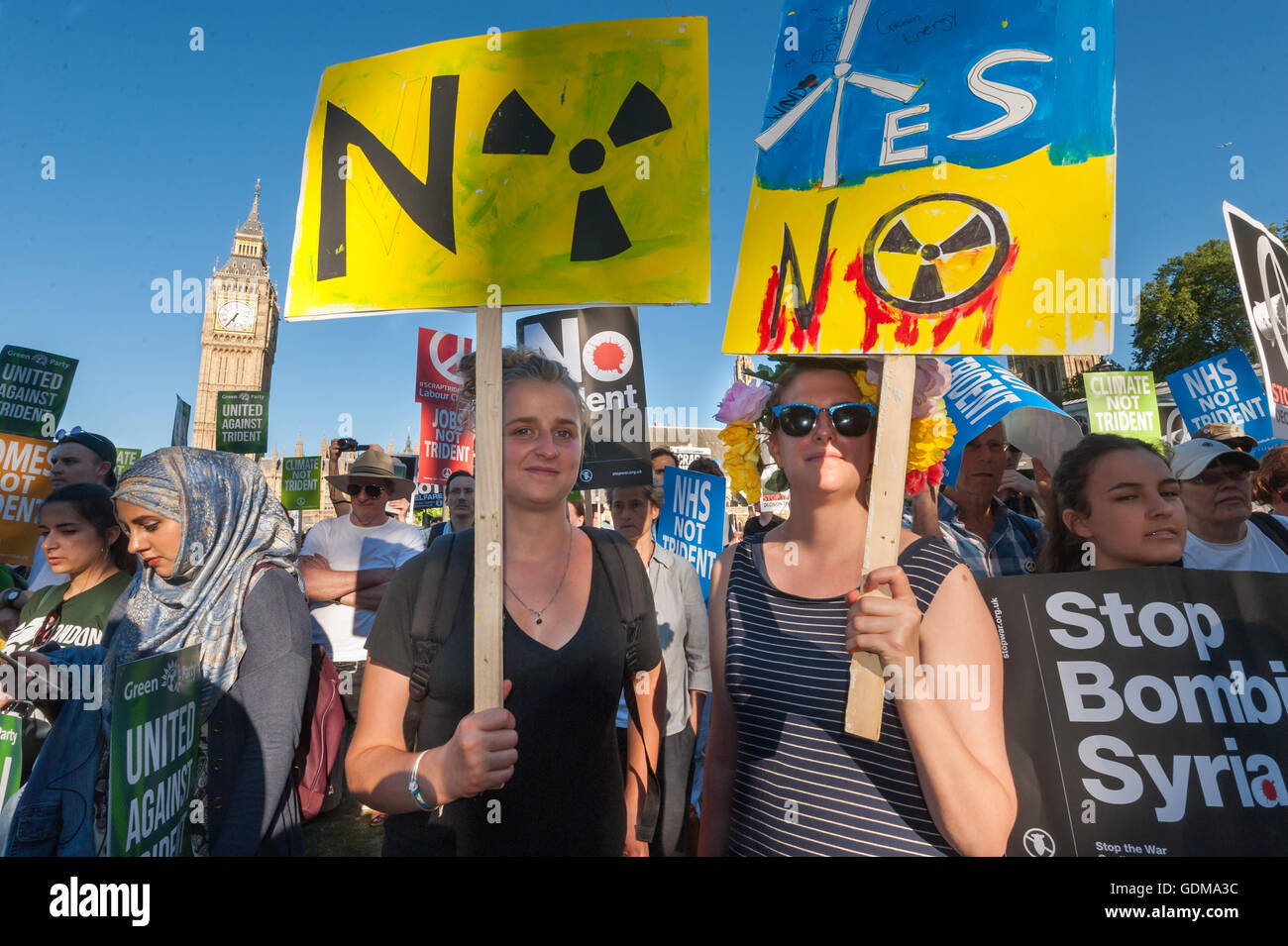London, UK. 18th July 2016. Protesters in the crowd with hand-painted placards at the CND rally outside Parliament taking place as the replacement for the UK's Trident nuclear submarines was being debated. Speakers included MPs and other politicians, peace campaigners and others who stressed that the independence of Trident and the idea of deterrence were myths and the use of nuclear weapons was illegal and immoral. Credit:  Peter Marshall/Alamy Live News Stock Photo