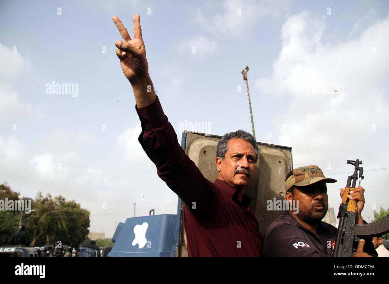 Muttahida Qaumi Movement leader Wasim Akhtar makes victory sign as he is being shifted to Karachi's Central Prison in a police van after rejected his interim bail in a terror facilitation case at an anti-terrorism court (ATC) in Karachi on Tuesday, July 19, 2016. Muttahida Qaumi Movement (MQM) leaders Wasim Akhtar and Rauf Siddiqui, and Pak Sarzameen Party president Anis Qaimkhani were taken into custody in a terror facilitation case after an anti-terrorism court (ATC) rejected their interim bail. Stock Photo