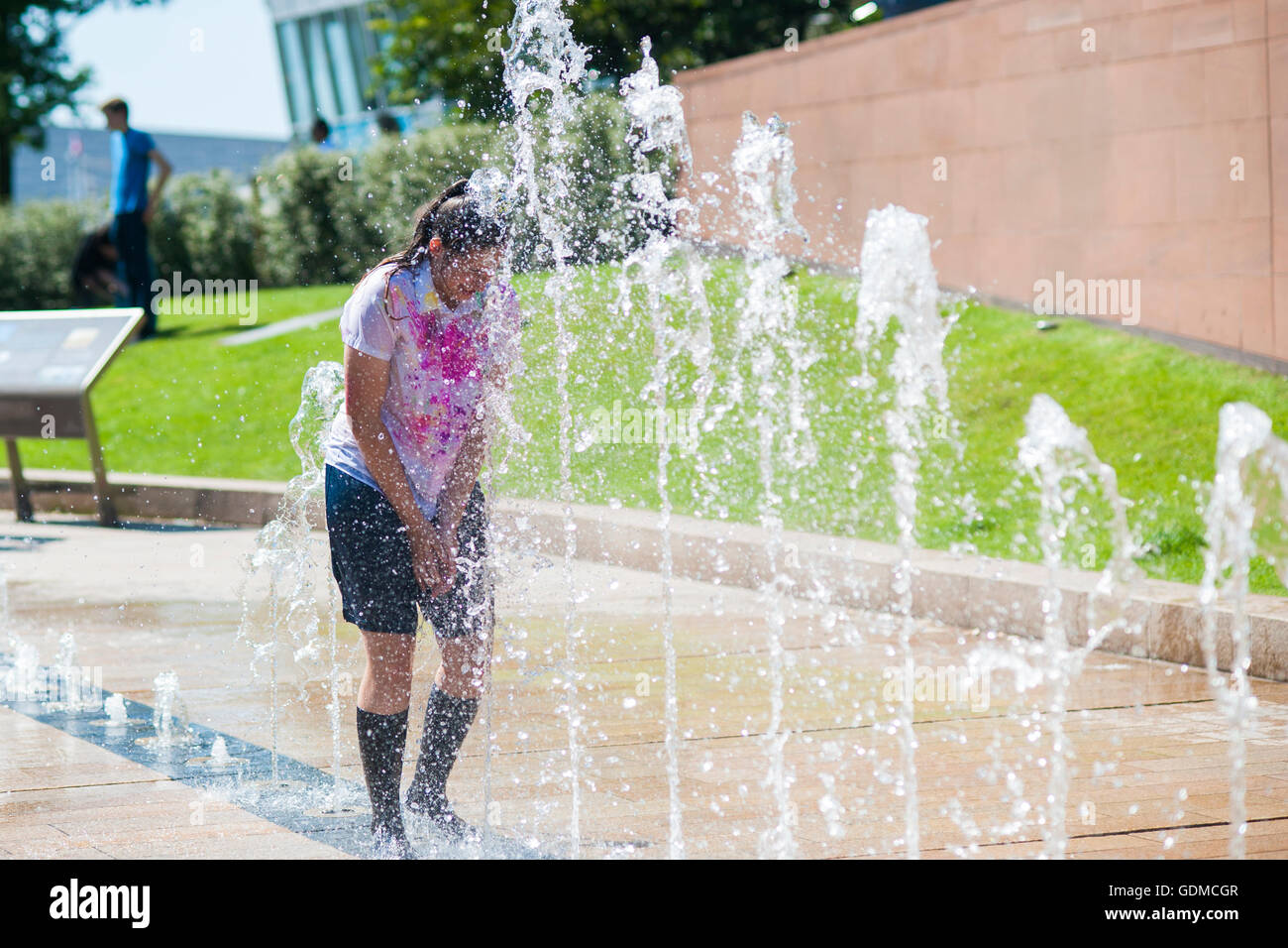 Liverpool, UK. 19th July 2016. A schoolgirl runs into a water fountain to cool down on the hottest day of the year. Credit:  Hayley Blackledge/Alamy Live News Stock Photo