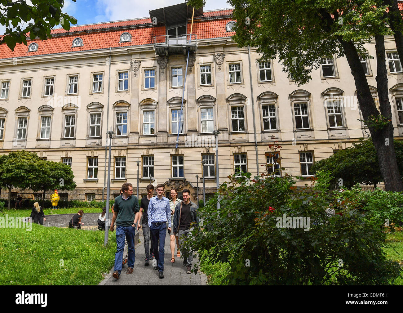 Students stand in front of the main building of the Viadrina European University in Frankfurt (Oder), Germany, 19 July 2016. Photo: Patrick Pleul/dpa Stock Photo